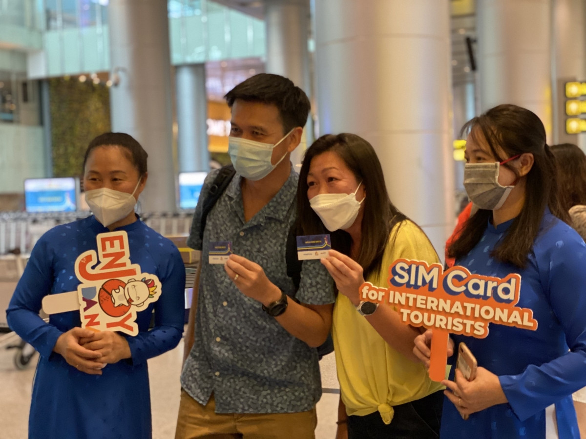 Foreign tourists are presented with Vinaphone SIM cards at the Da Nang airport (Photo: Thanh Nien)