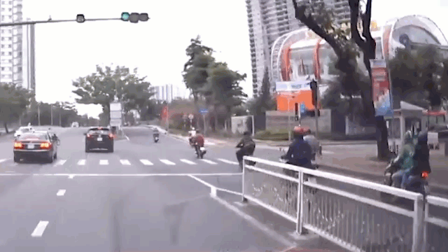Tránh người phụ nữ vượt đèn đỏ, ô tô lao thẳng vào cột đèn