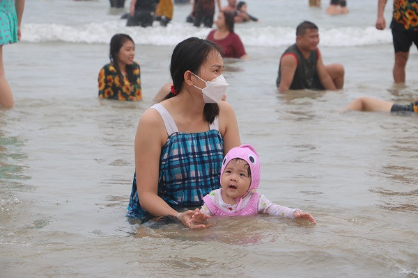 Một em nhỏ cùng mẹ tắm biển.
