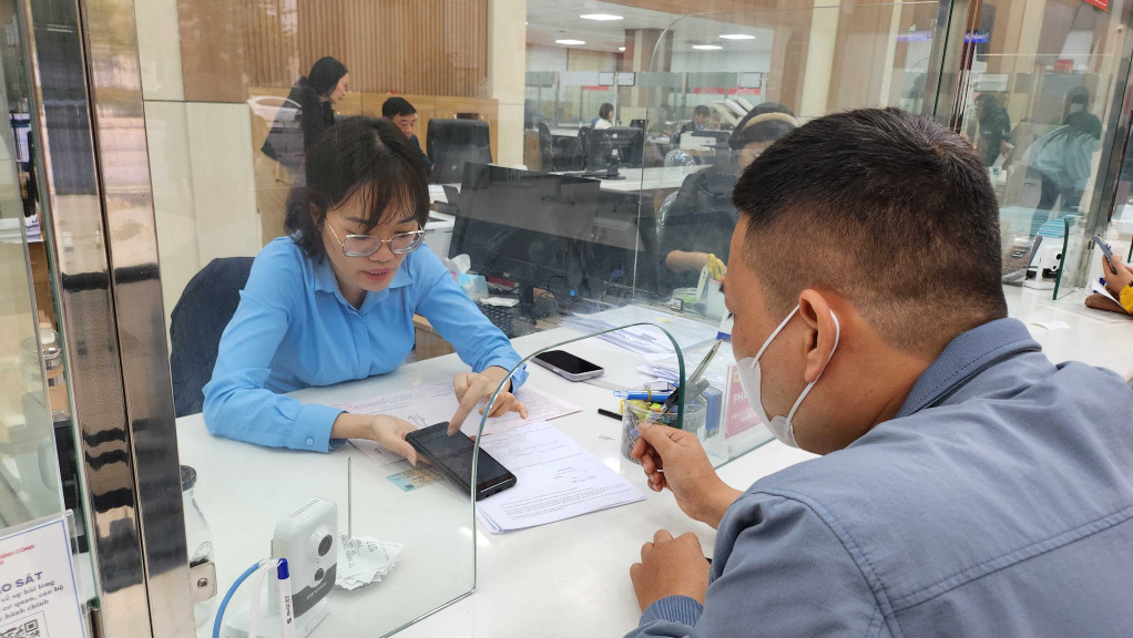 Cán bộ Trung tâm Hành chính công TP Hạ Long hướng dẫn người dân thực hiện TTHC qua dịch vụ công trực tuyến.