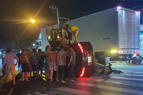 Người dân phá cửa xe, cứu tài xế kẹt trong xế hộp lật ngang giữa đường