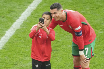 Ronaldo cười tươi chụp selfie với fan nhí chạy vào sân