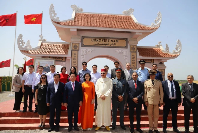 Đoàn đại biểu Đảng Cộng sản Việt Nam chụp ảnh lưu niệm cùng các lãnh đạo địa phương xung quanh Làng Việt Nam tại Maroc tại Cổng Việt Nam tại Maroc. (Ảnh: Hồng Minh/TTXVN)