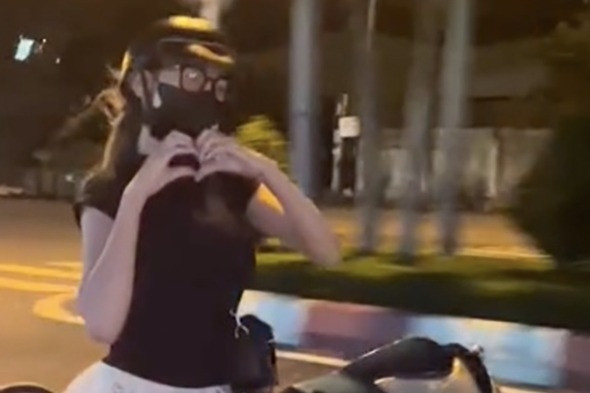 Cô gái buông hai tay 'diễn xiếc', tạo hình trái tim khi lái xe trên đường phố