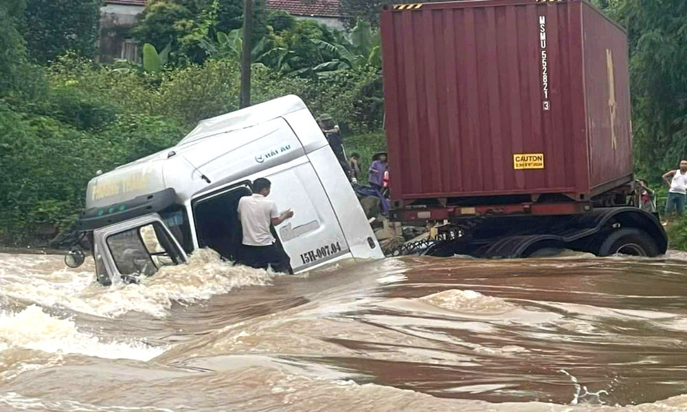 Thời điểm chiếc xe đầu kéo bị lũ cuốn, lái xe hoảng sợ tìm cách thoát ra. .jpg