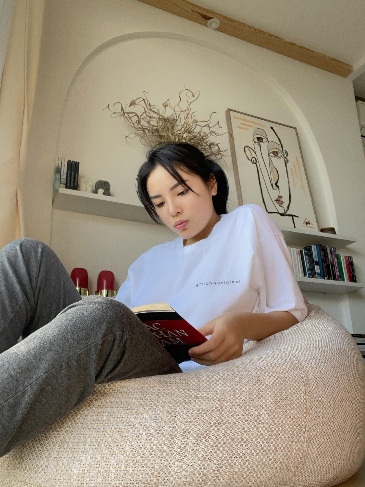 Ky Duyen ngoi doc sach tren ghe luoi.webp