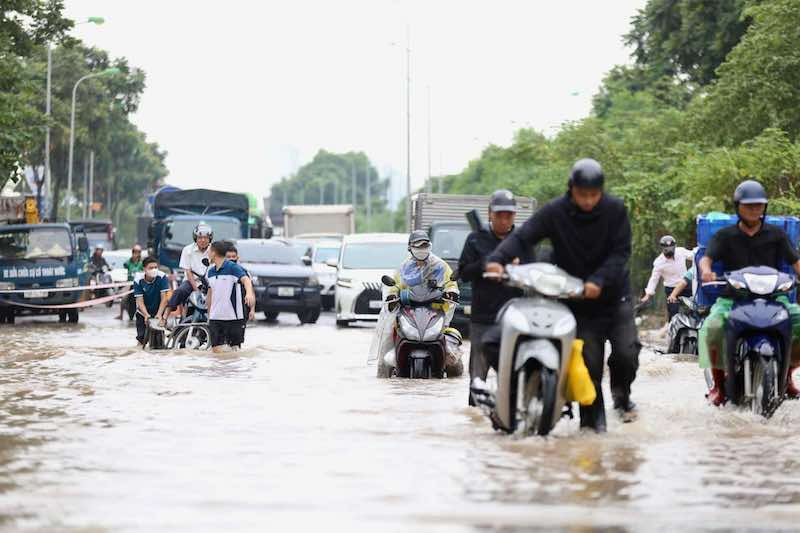 Trẻ em vượt tường, lội nước ngập đi học ở Hà Nội sau bão số 3