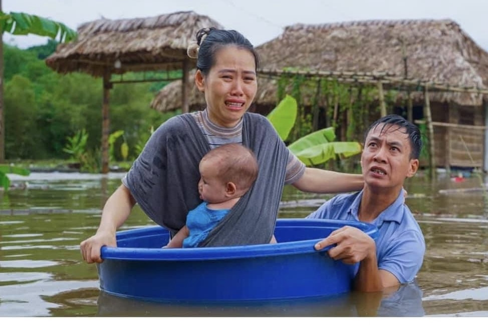 Sự thật về bức ảnh vợ chồng cùng con nhỏ khóc trong 'biển' nước lũ tại Hà Giang