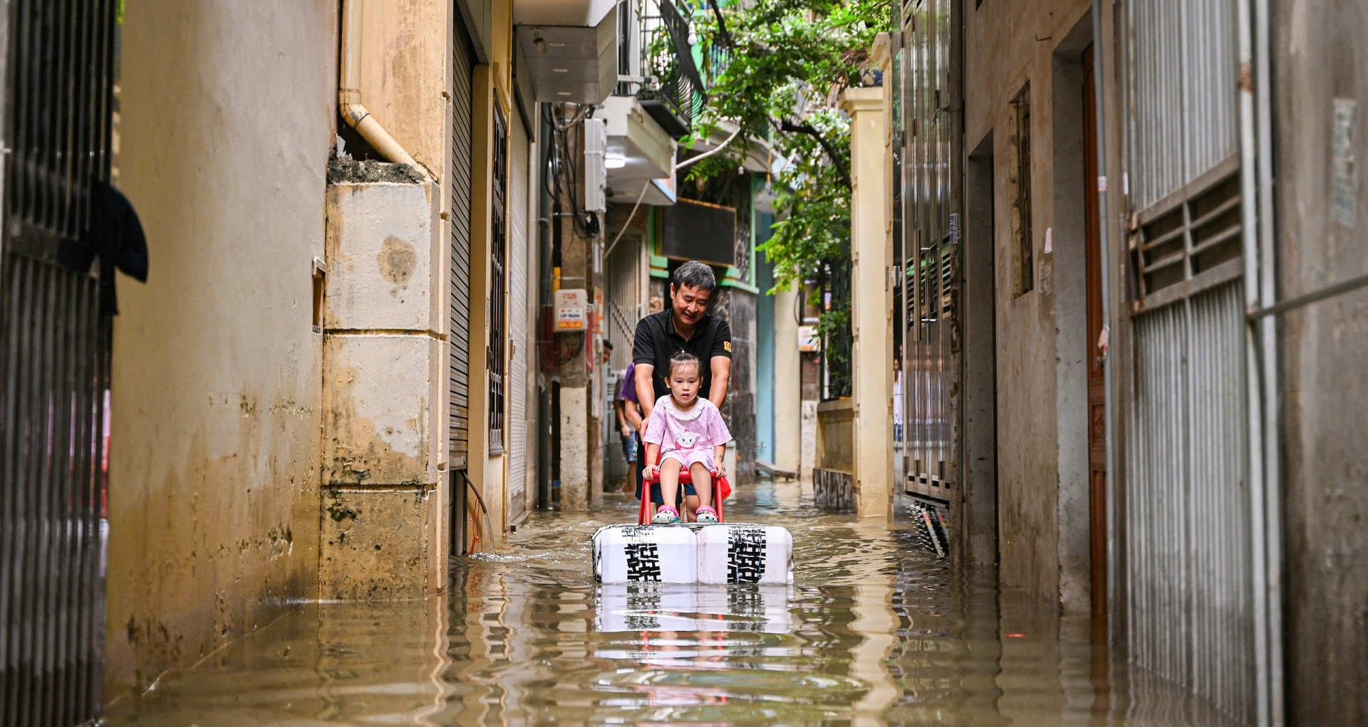 Phố nhỏ ở Hà Nội vẫn ngập như sông, ông làm bè đưa cháu đi dạo