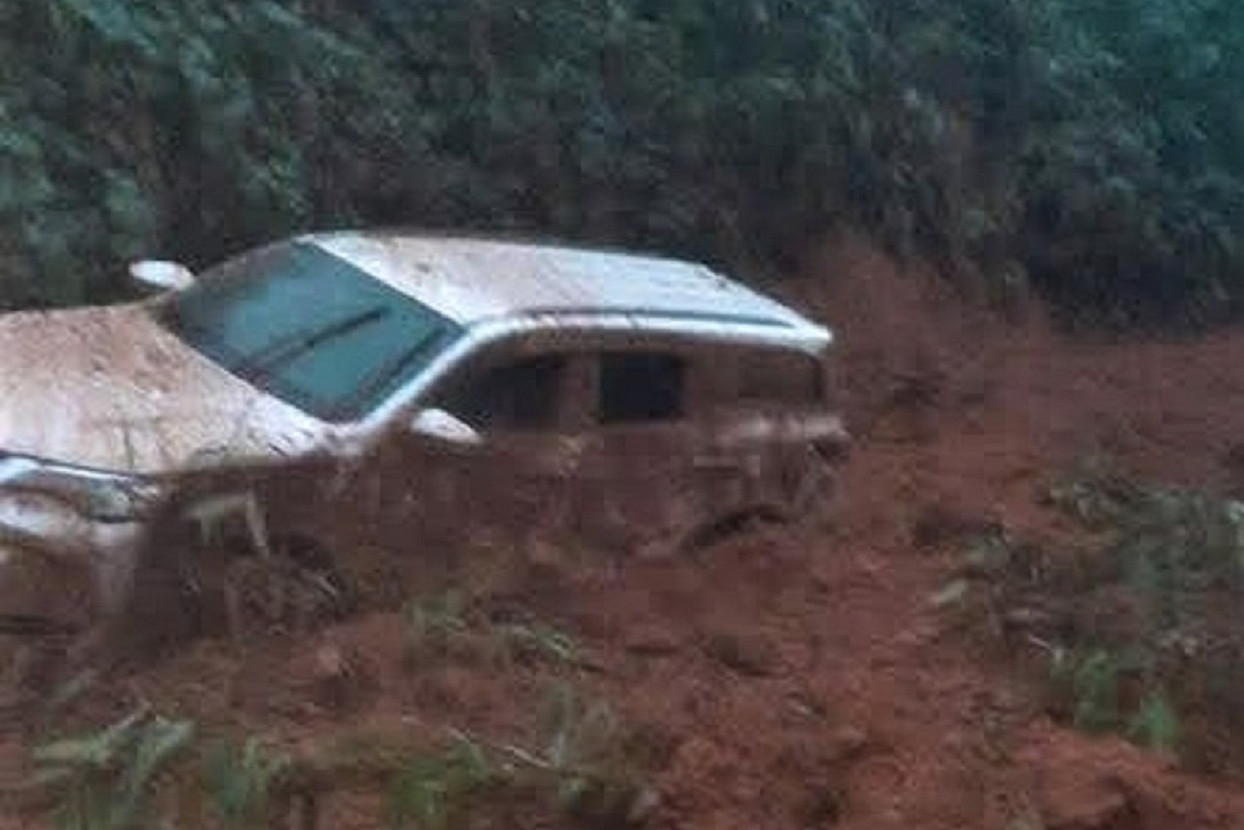 Ô tô 7 chỗ màu trắng bị đất, đá vùi lấp