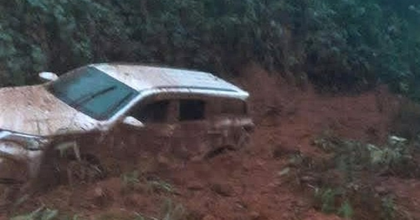 Ô tô 7 chỗ màu trắng bị đất, đá vùi lấp