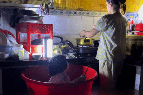 Đà Nẵng ngập lụt, mẹ trẻ đặt con vào chậu vừa trông vừa nấu vội bữa cơm chiều