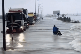 Khoảnh khắc đoàn xe tải làm 'lá chắn' giúp người đi xe máy vượt lũ gây xúc động