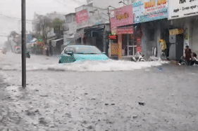 Chỉ sau một cơn mưa đường TPHCM lại thành 'sông', người và xe đua nhau 'bơi' trên phố
