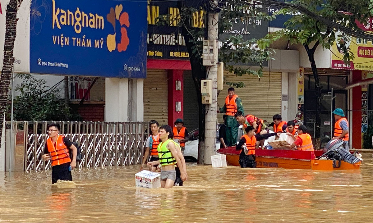 Nhiều đoàn thiện nguyện dầm mình trong nước để hỗ trợ người dân. .jpg