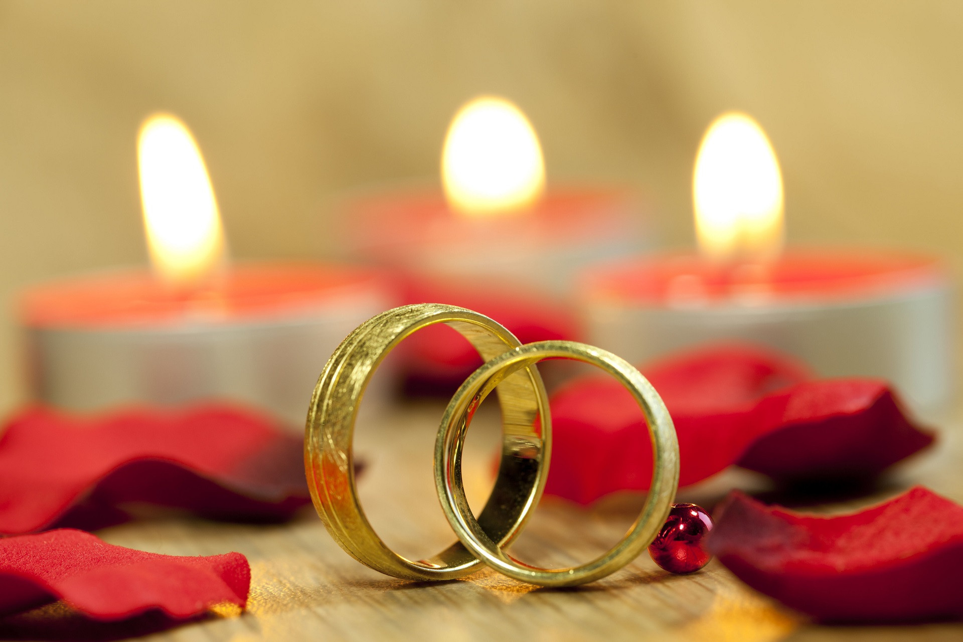 Vì 3 cây vàng cưới, mẹ chồng giận con dâu suốt nhiều năm 1 closeup shot wedding rings with background beautiful red roses candles table.jpg
