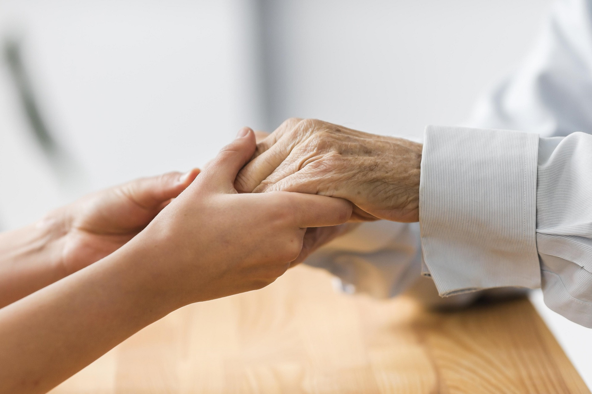 nurse holding senior man s hands comfort.jpg