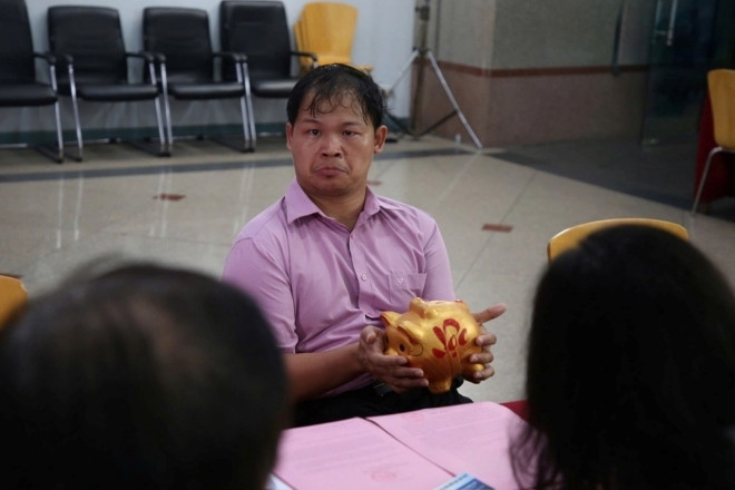 Người đàn ông đi lại khó khăn ôm heo đất đến ủng hộ bà con vùng lũ gây xúc động