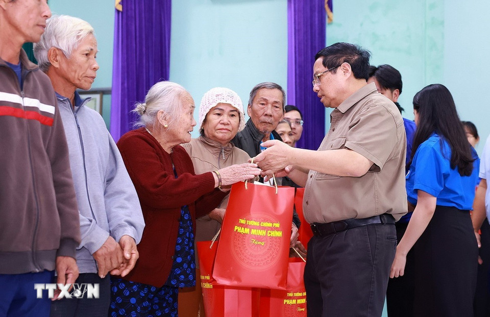 Thủ tướng Phạm Minh Chính tặng quà động viên hộ gia đình có nhà bị sập hoàn toàn do mưa lũ tại thôn Phú Hữu, xã Hòa Thịnh. (Ảnh: Dương Giang/TTXVN)