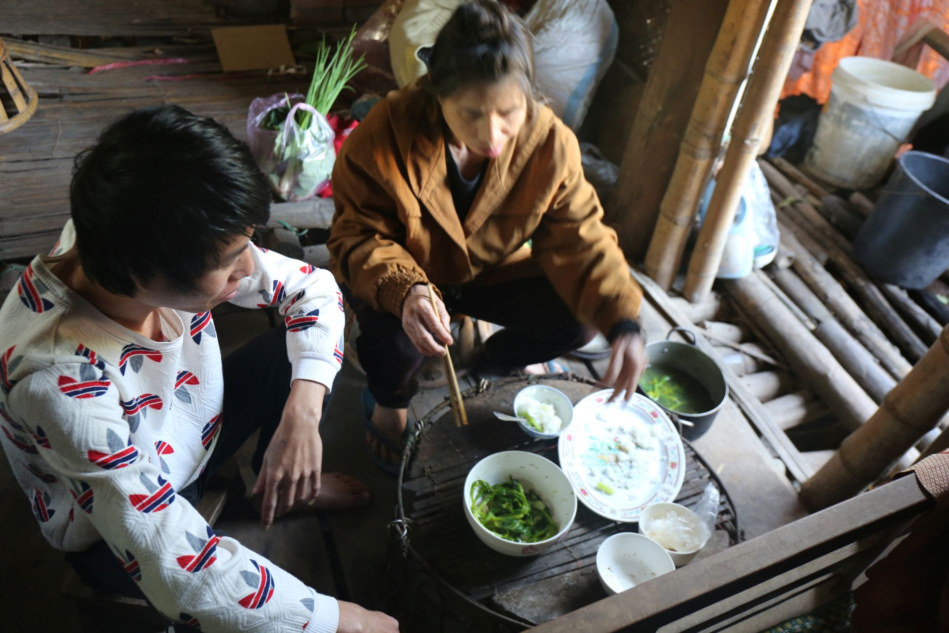 Bữa cơm của mẹ con bà Lô Thị Hoan chỉ là canh rau lỏng bỏng.JPG