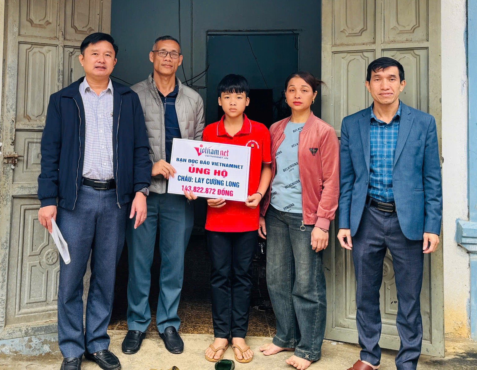 Đại diện Báo VietNamNet cùng chính quyền địa phương, trường THCS Lượng Minh trao quà cháu Cường Long.jpg