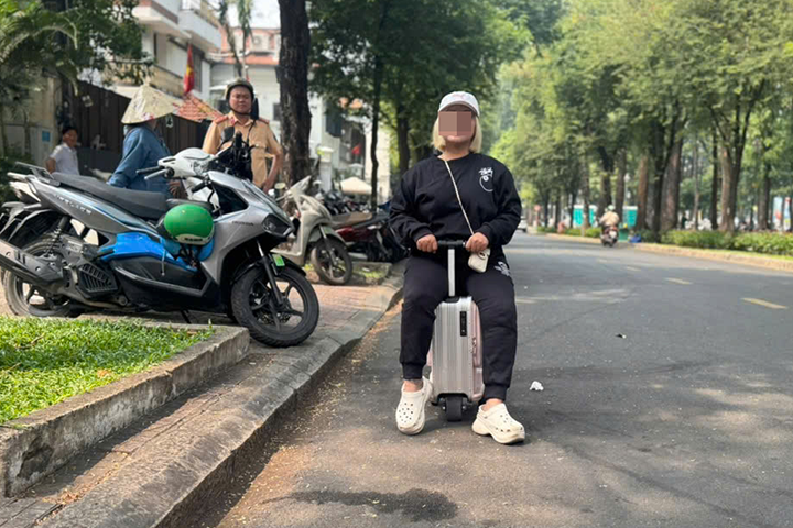 Xử phạt người phụ nữ 43 tuổi 'cưỡi' vali băng băng trên đường