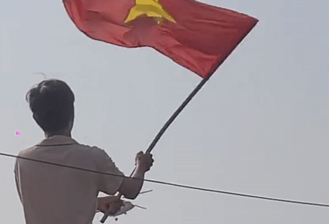 Nam thanh niên đứng trên mái nhà, vẫy cờ chào trực thăng gây bão mạng