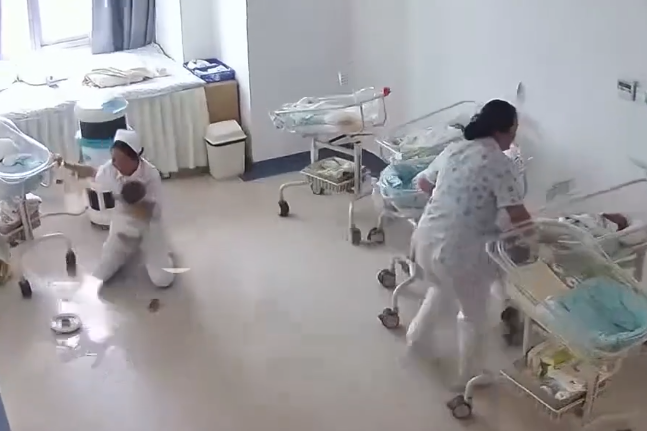 Nữ y tá quỳ gối, ôm chặt trẻ sơ sinh giữa trận động đất