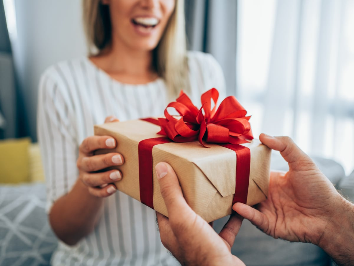 cheerful young woman receiving a gift from her boyfriend.jpg
