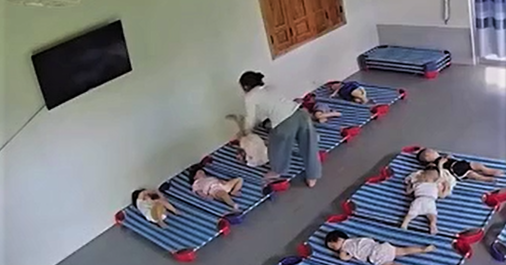 Bé 20 tháng tuổi đang nằm, cô giáo mầm non xách ngược chân đánh tới tấp