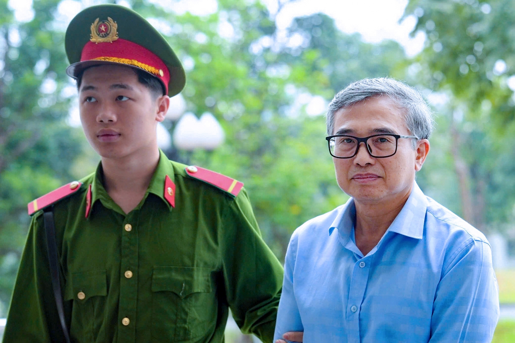 Hình ảnh dẫn giải cựu Thứ trưởng Hoàng Quốc Vượng và đồng phạm đến tòa