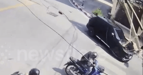 Cột điện bị kéo đổ đè trúng ô tô đang di chuyển trên đường
