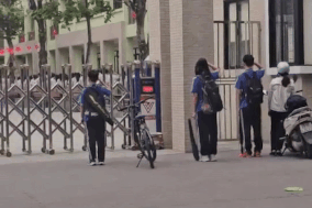 Đi học muộn, nhóm học sinh đứng nghiêm chào cờ rồi mới xin bảo vệ vào trường