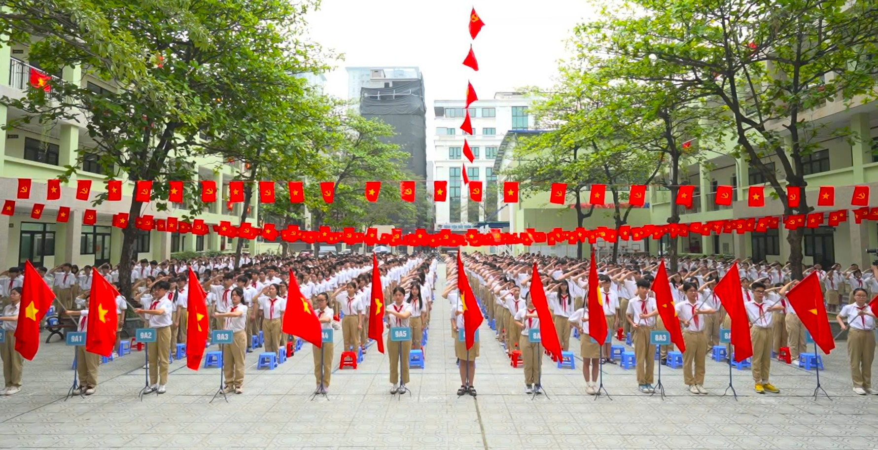 Đi học muộn, nhóm học sinh đứng nghiêm chào cờ rồi mới xin bảo vệ vào trường