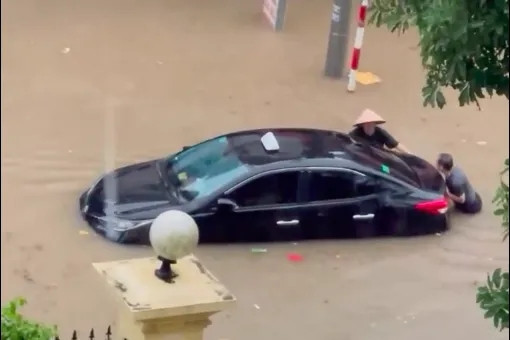 Người dân bì bõm đẩy ô tô ngập trong biển nước sau mưa lớn