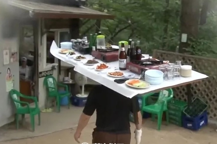 Chủ quán đội cả bàn ăn lên đầu, leo cầu thang thoăn thoắt phục vụ thực khách