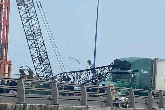 Cần cẩu công trình bất ngờ ngã ra đường, đè lên 2 ô tô ở TPHCM