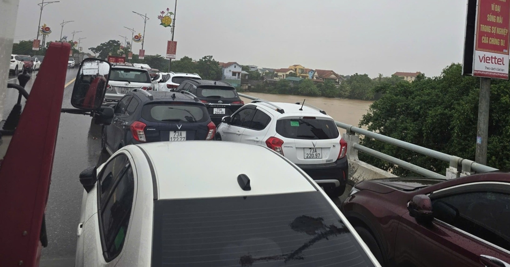 Mưa xối xả, người dân ở 'rốn lũ' Quảng Bình đưa ô tô lên cầu tránh ngập lụt