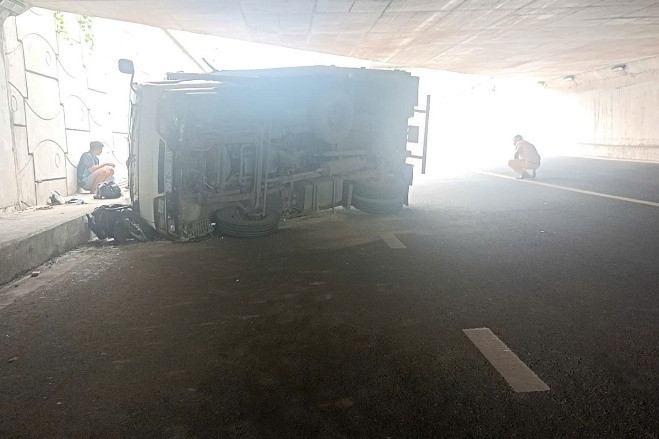 Ô tô tải biển xanh lật đè 2 xe máy ở của ngõ TPHCM, hai người bị thương