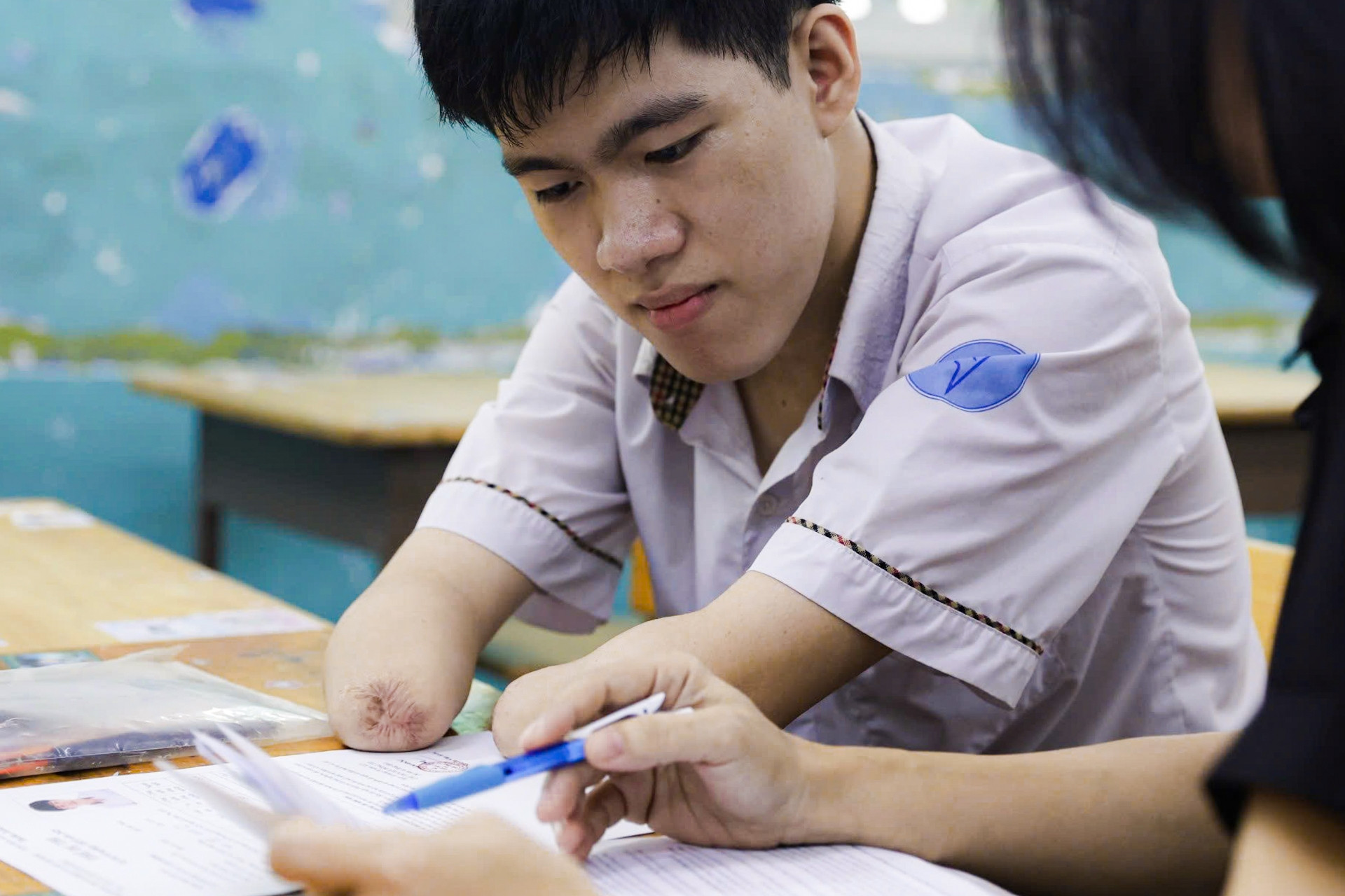 Nam sinh cụt tứ chi dùng cùi chỏ tự viết trọn vẹn bài thi Ngữ văn