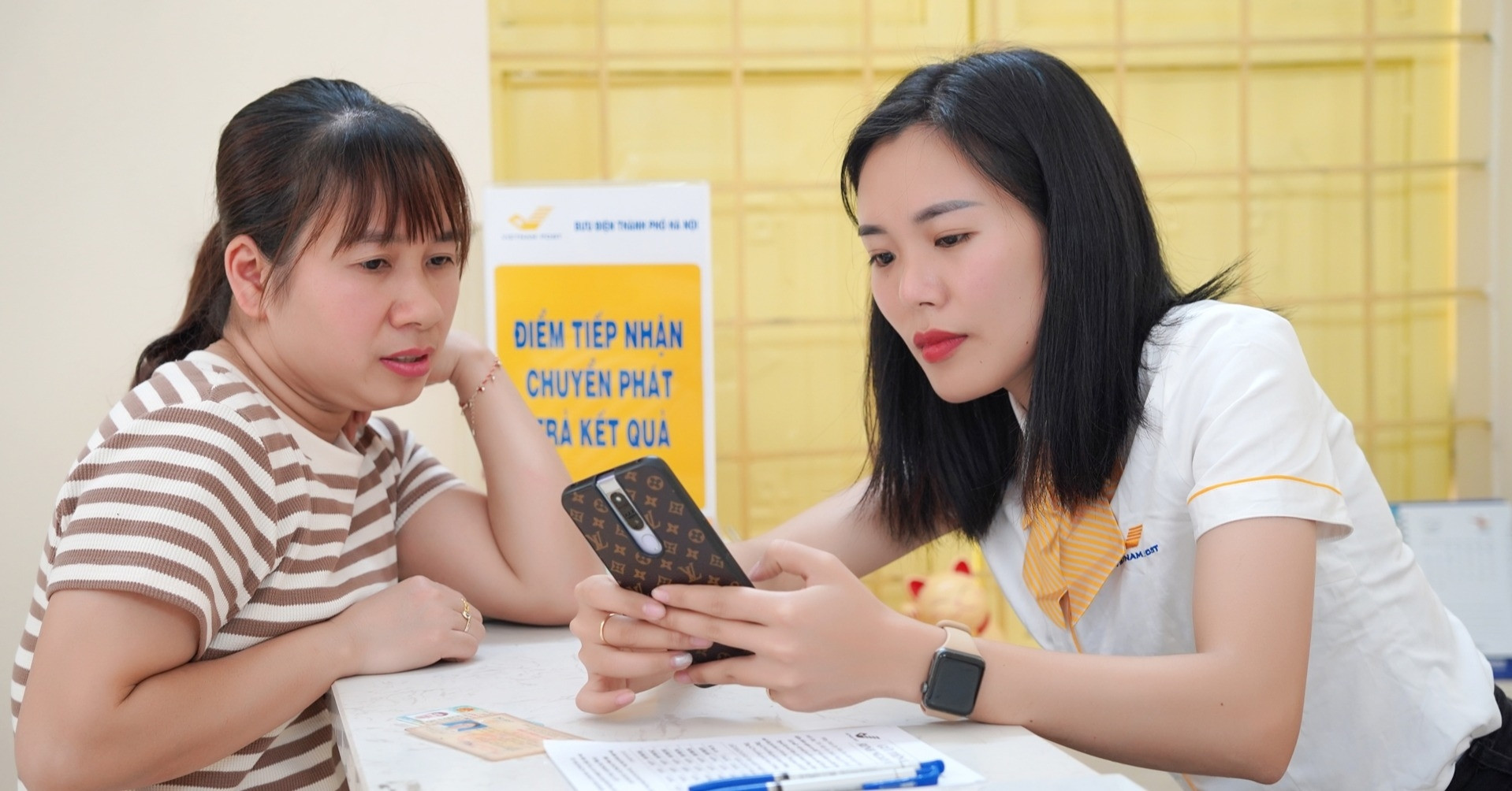 Nhân viên bưu điện tham gia hỗ trợ người dân Hà Nội dùng dịch vụ công trực tuyến