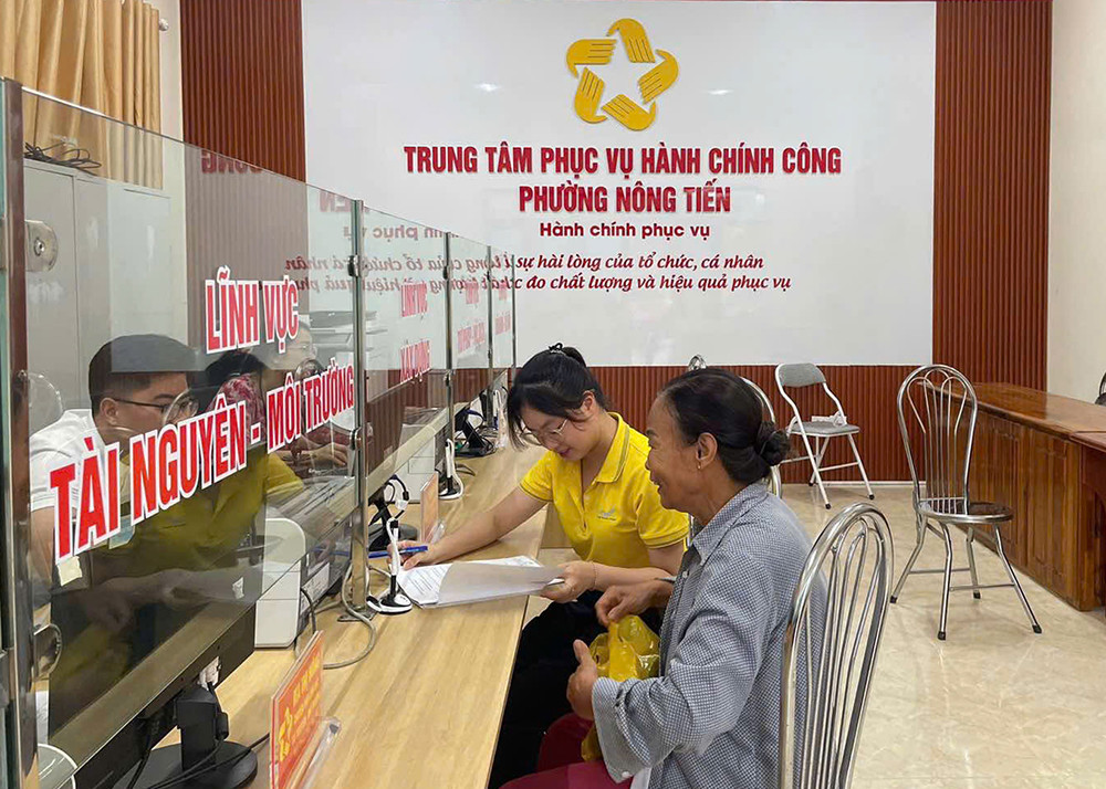 Nhân viên Bưu điện tỉnh Tuyên Quang hỗ trợ người dân tại TTPVHCC phường Nông Tiến.jpg