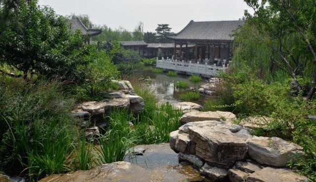 Classic elements of a Chinese garden stone water bridges roofs plants.png