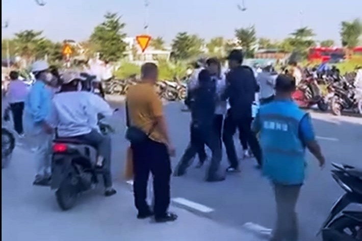 2 người mặc đồng phục bảo vệ hành hung nam công nhân trước cổng công ty