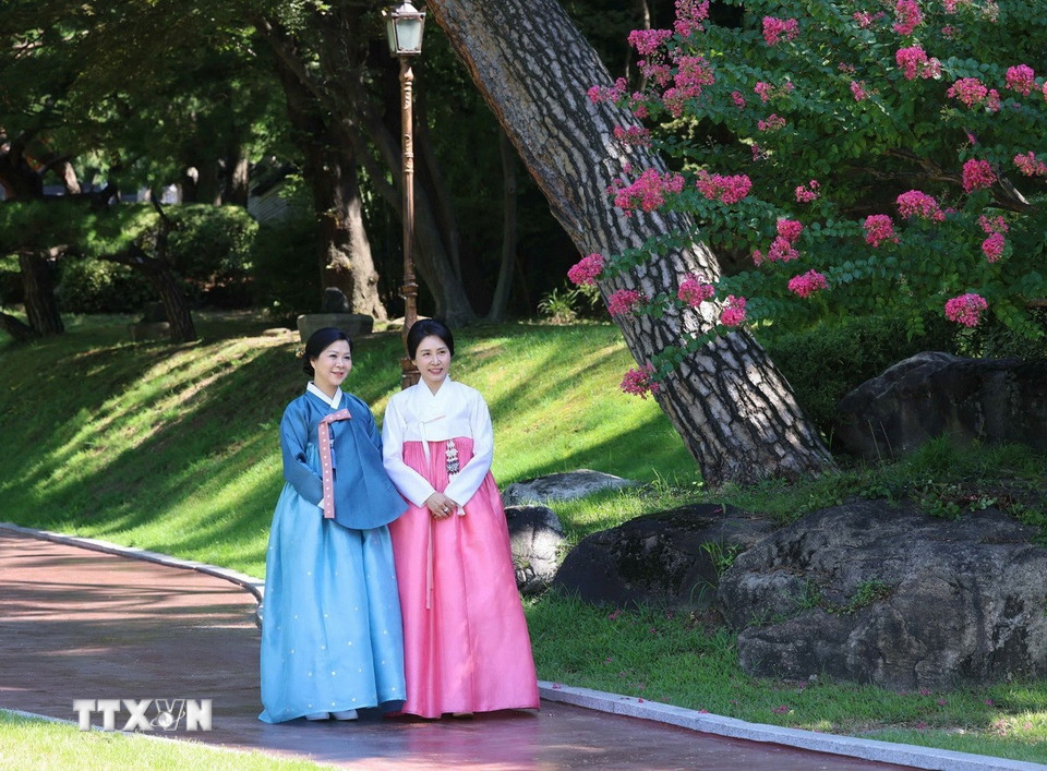 Phu nhân Ngô Phương Ly và Phu nhân Kim Hye Kyung đi dạo và chụp ảnh chung trong khuôn viên Nhà Xanh. (Ảnh: Thống Nhất/TTXVN)