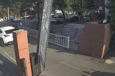 Cụ bà ngồi trên xe ba bánh bị thanh barie hạ đập trúng khi đi vào bãi đỗ xe