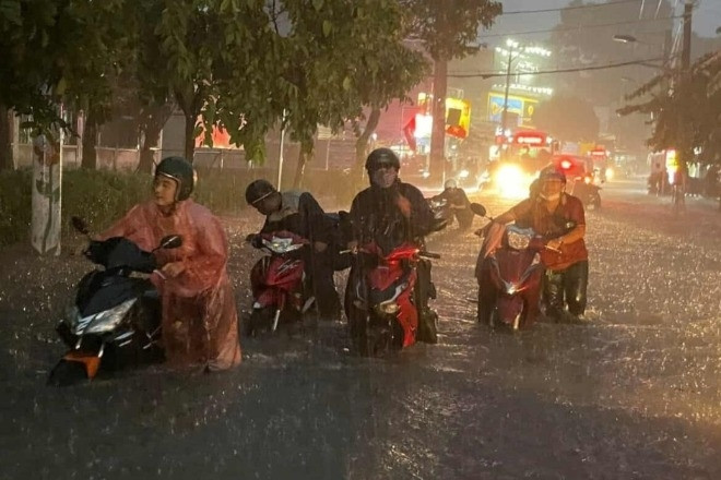Mưa ngập lút bánh xe, người dân TPHCM vật lộn giữa dòng nước