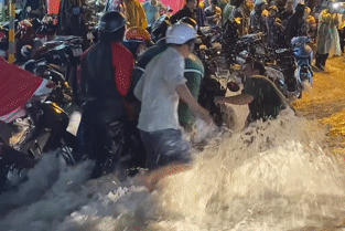 Nước chảy xiết cuốn trôi xe máy, người dân TPHCM lao vào giải cứu