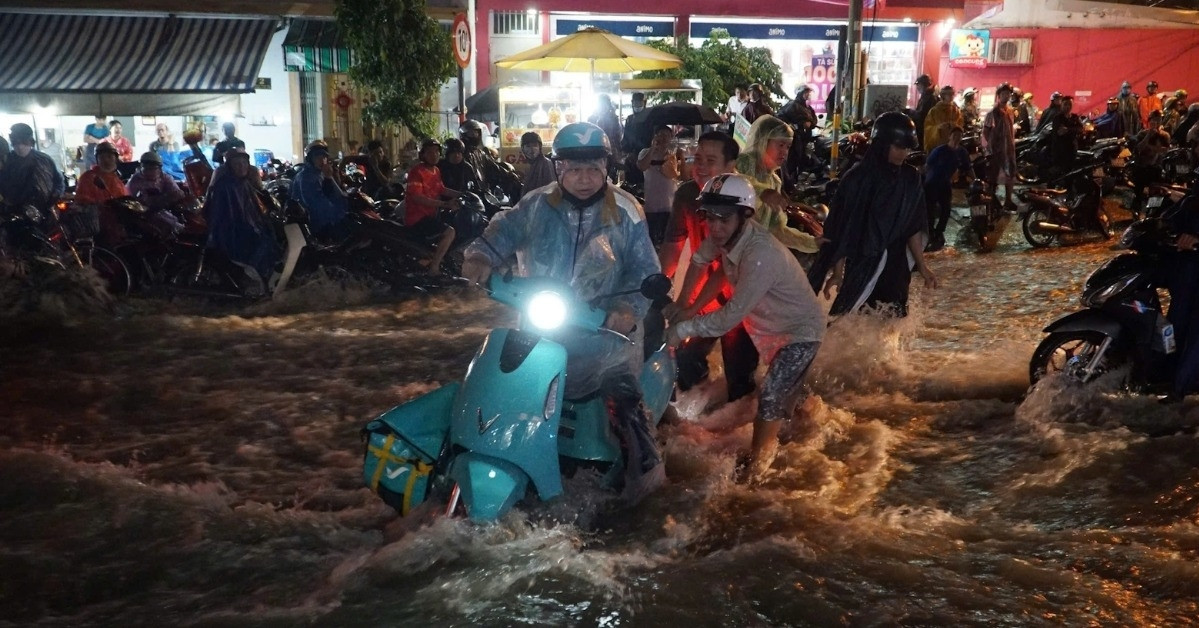 Nước chảy xiết cuốn trôi xe máy, người dân TPHCM lao vào giải cứu