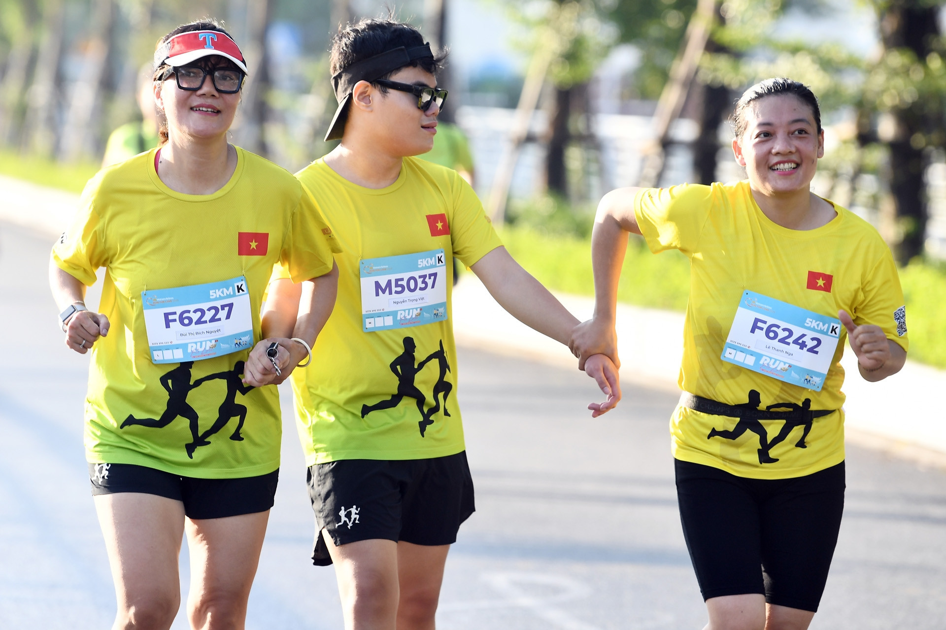 Người khiếm thị được dắt tay ở giải chạy bên Hồ Tây